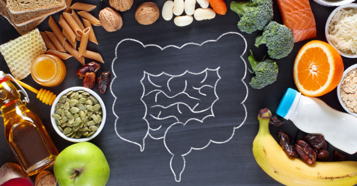 healthy foods surrounding drawing of digestive system