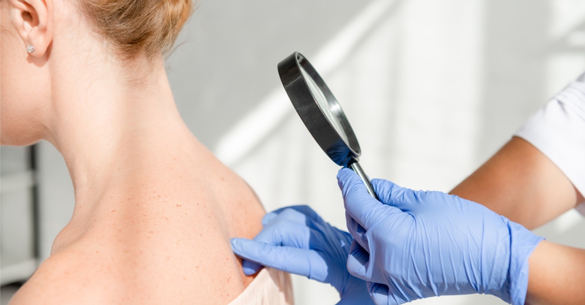 Woman getting examined under magnifying glass